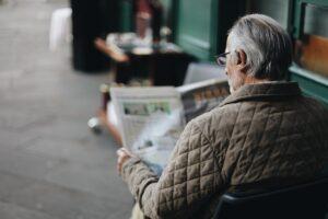 man sitting reading newspaper