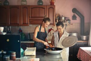 cheerful women cooking together in kitchen